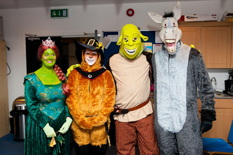 Four people wearing Princess Fiona, Puss in Boots, Shrek and Donkey fancy dress costumes at the 2011 Christmas parade in Guernsey